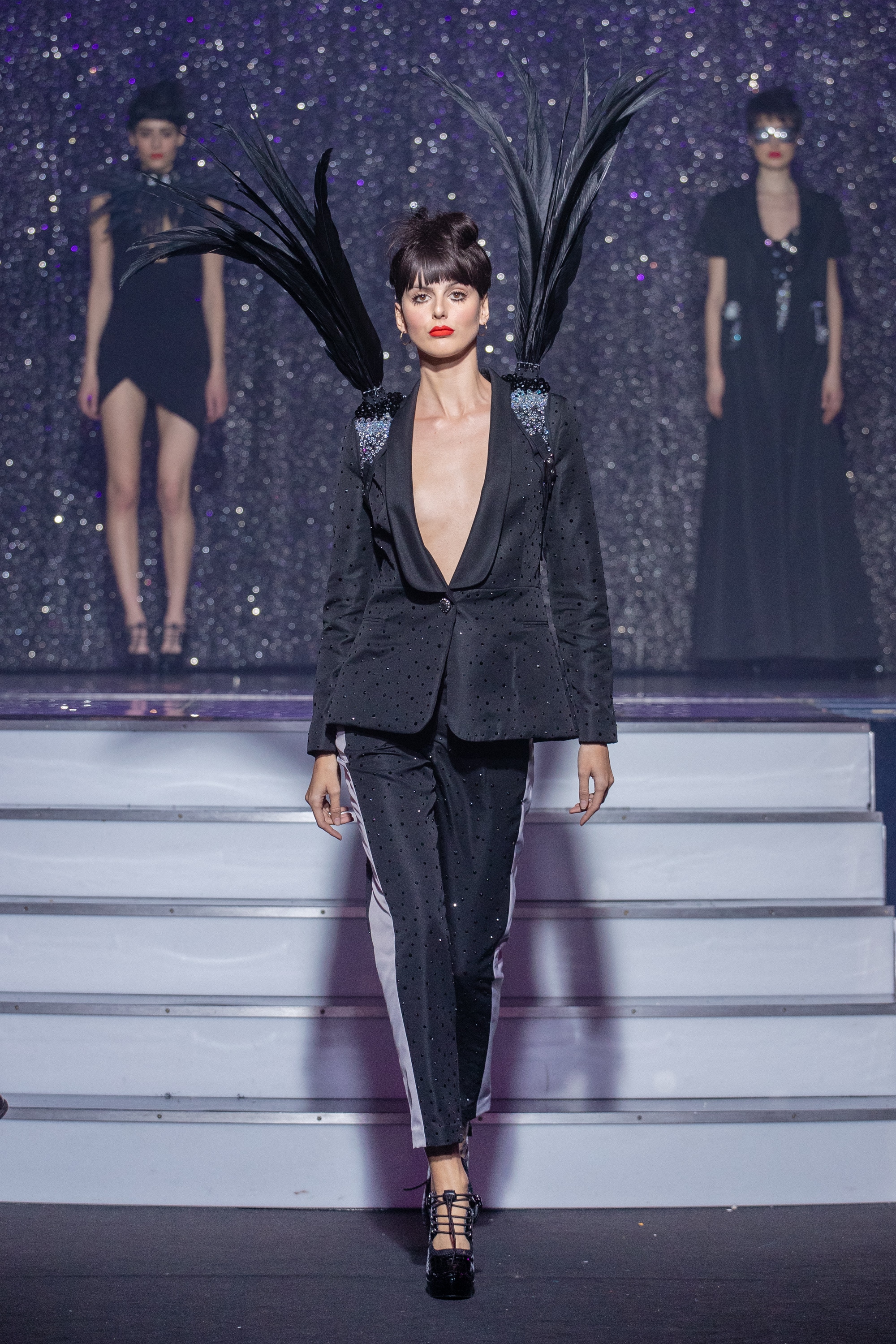 a model wearing  black silk  outfit  crystal  harness feathers  by on aura tout vu haute couture spring summer 2020