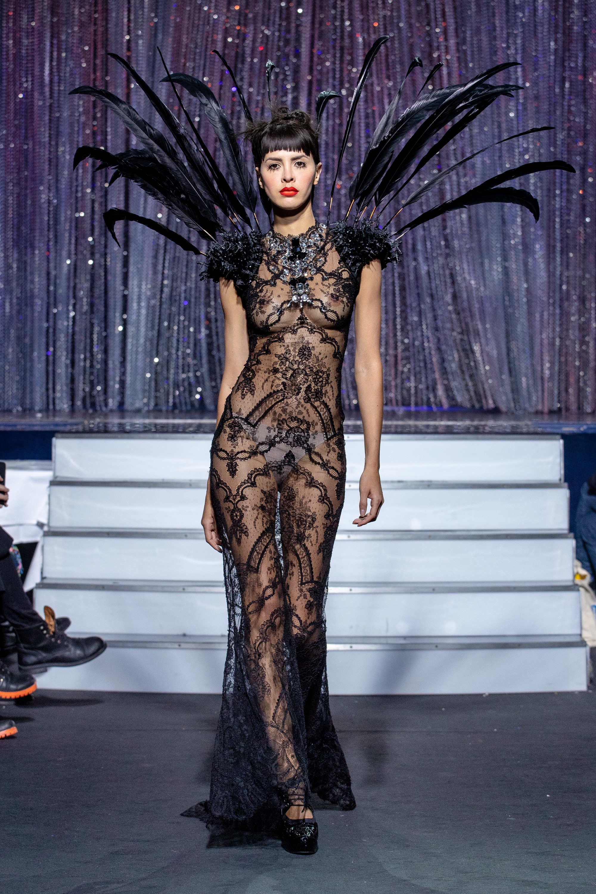 a model wearing  black lace dress  crystal  and feathers by on aura tout vu haute couture spring summer 2020