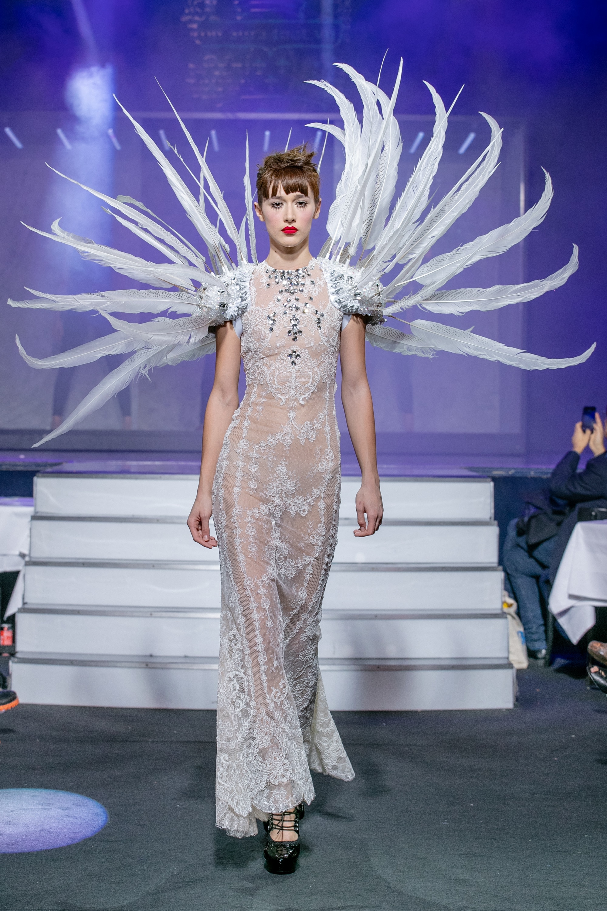 a model wearing  white silk  wedding dress  crystal  and white feathers  by on aura tout vu haute couture spring summer 2020