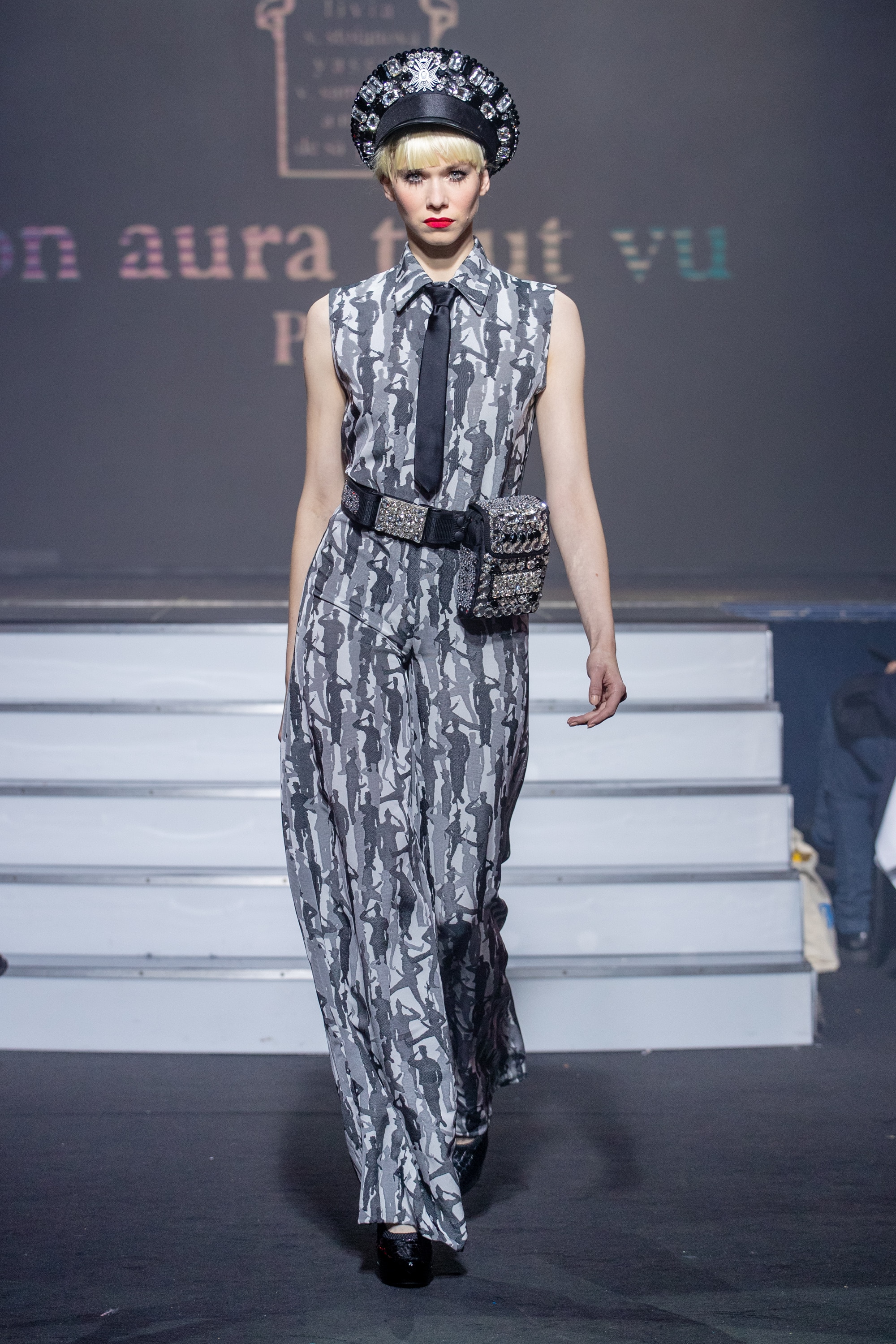 a model wearing Military silver silk  outfit  crystal hat and belt  by on aura tout vu haute couture spring summer 2020