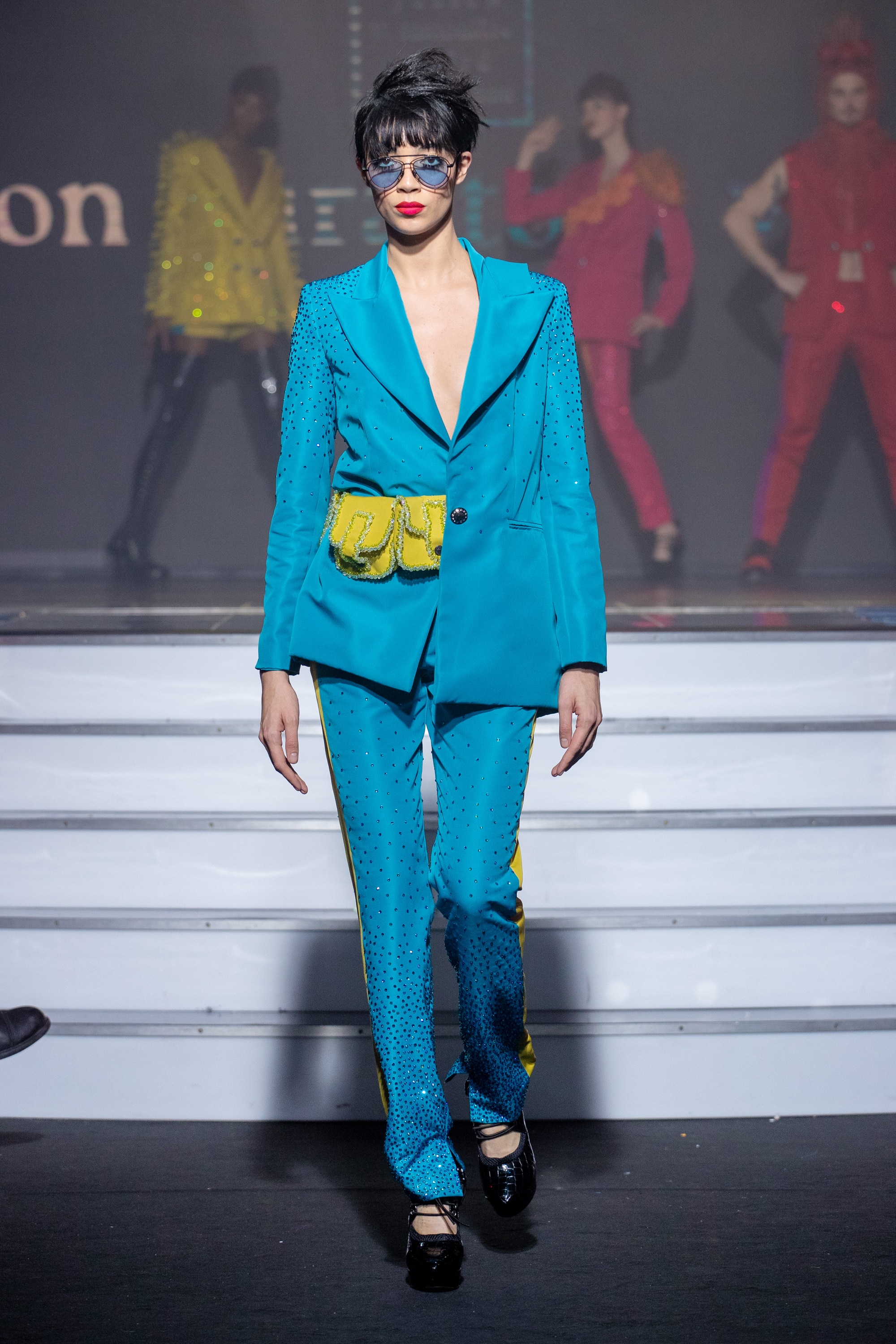 a model wearing  bleu and green  silk  outfit  crystal  and belt  by on aura tout vu haute couture spring summer 2020