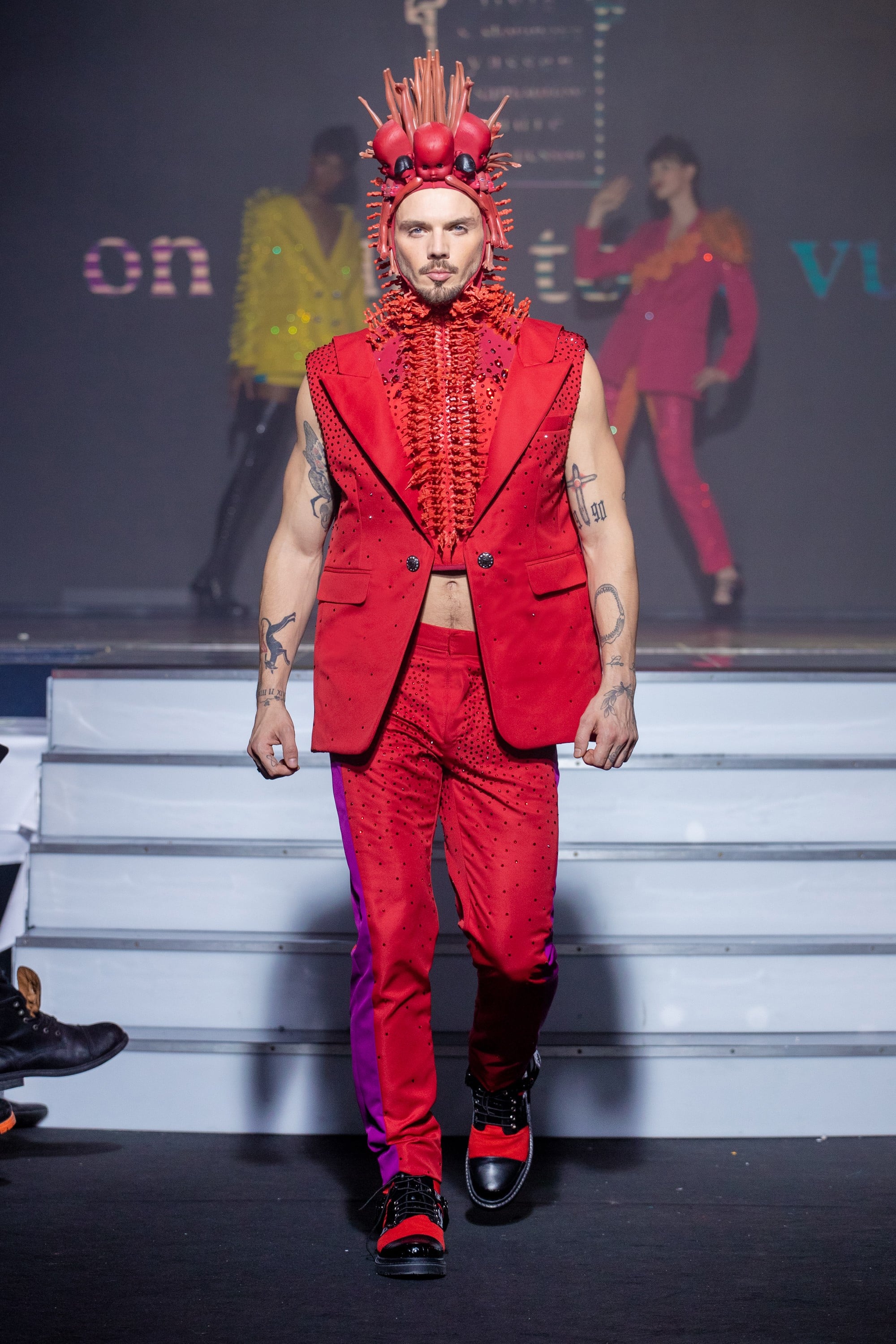 a men model wearing  red and violet silk  outfit  crystal  hat   by on aura tout vu haute couture spring summer 2020
